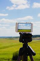 smartphone op statief zomerlandschap vastleggen foto