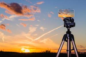smartphone op statief vastleggen beeld van prachtige zonsondergang foto