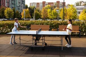 fotografie van tafel tennis Oppervlakte in de openbaar park. straat pingpong sport- wedstrijden in voorjaar dag. levensstijlen van groot stad. mensen spelen tafel tennis actief. foto