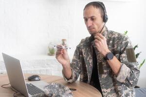 leger technisch onderhoud, lucht dwingen concept. handen van een Mens in uniform Holding een zilver speelgoed- vliegtuig. een middelbare leeftijd volwassen Mens in een groen camouflage uniform. binnenshuis. foto