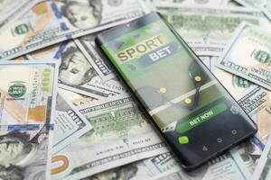 smartphone met het gokken mobiel toepassing met geld detailopname. sport en wedden concept foto