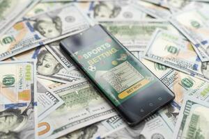 smartphone met het gokken mobiel toepassing met geld detailopname. sport en wedden concept foto
