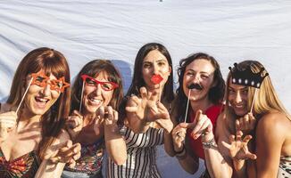 groep van vrouw vrienden hebben pret met partij accessoires Aan de daken foto