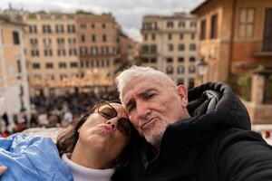 gelukkig midden- oud paar van toeristen Aan vakantie nemen een selfie in voorkant van de beroemd Trinita dei monti trappenhuis in Rome foto