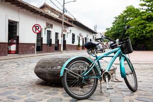 wijnoogst blauw fiets geparkeerd Bij de mooi straten in de omgeving van de centraal plein van de erfgoed stad- van guaduas gelegen in de afdeling van cundinamarca in Colombia. foto