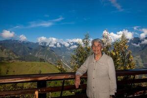 senior vrouw toerist op zoek Bij de verbazingwekkend landschappen van de centraal bereiken Aan de stijgen naar de hoog van brieven tussen de steden van Fresno en manizales in Colombia foto