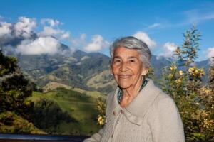 senior vrouw toerist op zoek Bij de verbazingwekkend landschappen van de centraal bereiken Aan de stijgen naar de hoog van brieven tussen de steden van Fresno en manizales in Colombia foto