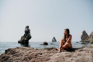 vrouw zomer zee. gelukkig vrouw zwemmen met opblaasbaar donut Aan de strand in zomer zonnig dag, omringd door vulkanisch bergen. zomer vakantie concept. foto