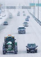 sneeuwploegen en auto's op de snelweg foto