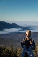 vrouw geniet van de frisse lucht van de bergen tijdens het wandelen naar de top van de richardson foto