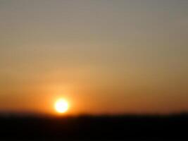 spectaculair zonsondergang over, oranje zon stijgende lijn omhoog over- de horizon foto