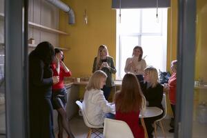 vrouw kantoor personeel hebben een koffie breken in de kantoor keuken foto