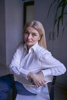 portret van een blond vrouw in jeans en een wit overhemd in de kantoor foto