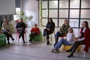 mensen in de hal zittend Aan poefs en stoelen luister naar de prestatie van hun collega Aan stadium foto