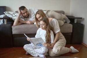 ouders lezen een boek met dochter foto