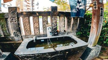 een altaar met een water Zuivering faciliteit.japan, osaki inari altaar, namiyoke inari altaar, gelegen in tsukuda, chuo afdeling, tokyo foto