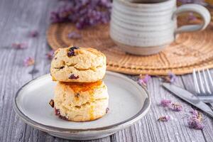 detailopname van traditioneel Brits scones Aan een bord met een thee kop en bloem wazig achtergrond foto