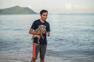 man en hond reizen op zee strand