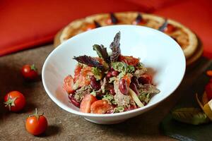 wit kom gevulde met salade De volgende naar vers tomaten foto