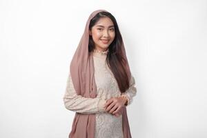 portret van mooi Aziatisch moslim vrouw vervelend sluier hijab geven met formeel houding glimlachen naar de camera, staand over- geïsoleerd wit achtergrond foto