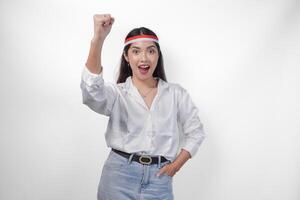 opgewonden jong Aziatisch vrouw vervelend land vlag hoofdband en balanceren handen terwijl vieren Indonesisch onafhankelijkheid dag geïsoleerd Aan wit achtergrond foto