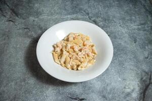 romig garnaal pasta geserveerd in bord geïsoleerd Aan achtergrond top visie van snel voedsel Italiaans neef foto