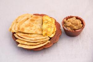 desi ontbijt omelet, halwa en paratha geserveerd in schotel geïsoleerd Aan achtergrond top visie van banglades ontbijt foto