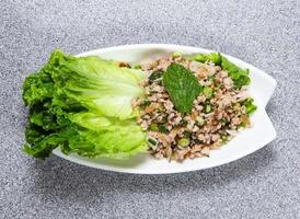 fijngehakt varkensvlees salade geserveerd met sla blad geserveerd in schotel geïsoleerd Aan grijs achtergrond top visie van hong Kong voedsel foto