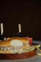 tonijn ei belegd broodje met Patat en mayonaise dip geserveerd in houten bord geïsoleerd Aan donker achtergrond kant visie van ontbijt voedsel foto
