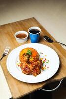 kip majboos biryani rijst- Pulao geserveerd in bord met saus, verkoudheid drankje, lepel en vork geïsoleerd Aan houten bord kant visie van Arabisch voedsel foto