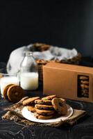 knapperig koekjes biscuits geserveerd in bord met koekje doos en glas van melk geïsoleerd Aan tafel kant visie van Amerikaans cafe gebakken voedsel foto