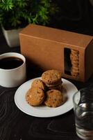 knapperig koekjes biscuits geserveerd in bord met koekje doos, zwart koffie en glas van water geïsoleerd Aan tafel kant visie van Amerikaans cafe gebakken voedsel foto