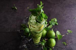 citroen munt mojito geserveerd in beschikbaar glas geïsoleerd Aan tafel kant visie van gezond drinken foto