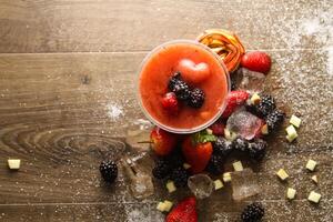 vers aardbei en moerbei sap geserveerd in beschikbaar glas geïsoleerd Aan tafel top visie van gezond ochtend- zomer fruit sap drinken foto