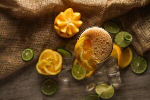 vers oranje sap met citroen en ijs kubus geserveerd in beschikbaar glas geïsoleerd Aan tafel top visie van gezond ochtend- sap drinken foto