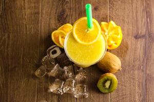 vers passie fruit sap met oranje en ijs kubus geserveerd in beschikbaar glas geïsoleerd Aan tafel top visie van gezond ochtend- sap drinken foto