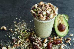 avocado datums schudden met cachou noot en pistache geserveerd in beschikbaar glas geïsoleerd Aan tafel kant visie van gezond drinken foto