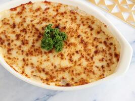 gebakken macarona bechamel geserveerd in schotel geïsoleerd Aan tafel detailopname top visie van Italiaans voedsel foto