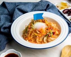 Thais stijl pittig gemengd vis udon noedels geserveerd in kom geïsoleerd Aan servet kant visie Japans voedsel Aan tafel foto