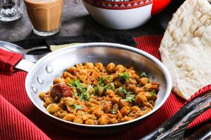basher bonen of channa massaal, kuiken erwten geserveerd in schotel geïsoleerd Aan rood mat top visie Aan tafel Arabisch voedsel foto