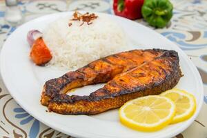 gegrild Zalm met rijst- en citroen plak geserveerd in schotel geïsoleerd Aan tafel top visie van Arabisch voedsel foto