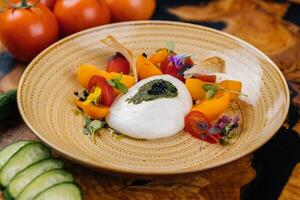 burrata salade met kers tomaat, komkommer, aardbei, bloem en blad geserveerd in schotel geïsoleerd Aan tafel kant visie van gezond biologisch salade foto