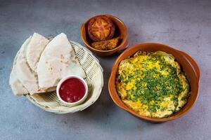 Spaans omelet met brood, gebakken tomaat en saus geserveerd in schotel geïsoleerd Aan grijs achtergrond top visie van Bahrein voedsel foto