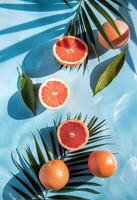 grapefruits, sinaasappelen, en palm bladeren Aan blauw oppervlakte foto