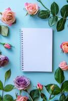 notitieboekje omringd door bloemen Aan blauw achtergrond foto