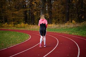 vrouw rennen Bij stadion bijhouden foto