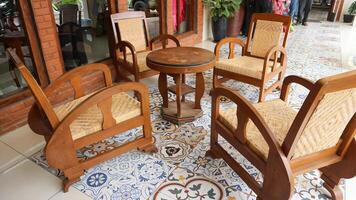 houten wijnoogst bruin teak stoel buitenshuis Aan veranda van Javaans huis of joglo met houten muur foto