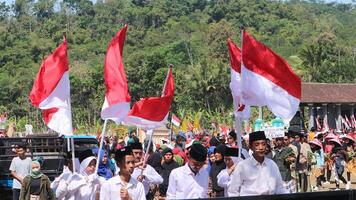 ambarawa, augustus 17e 2023. Indonesisch studenten brengen rood wit vlaggen in ceremonie vieren onafhankelijkheid dag. foto