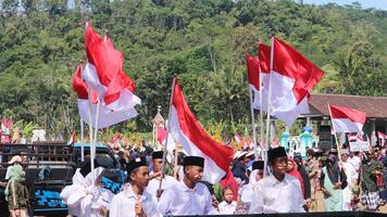 ambarawa, augustus 17e 2023. Indonesisch studenten brengen rood wit vlaggen in ceremonie vieren onafhankelijkheid dag. foto