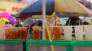 netjes arrangement van bevroren thee en oranje sap in een kop verkocht Aan de kant van de weg. foto